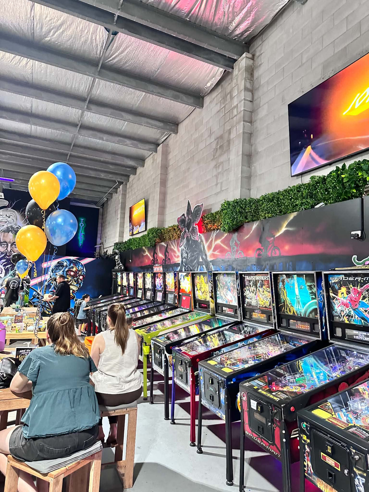 Birthday party balloons beside the row of pinball machines at Castlecade, Rising Sun FPV Townsville